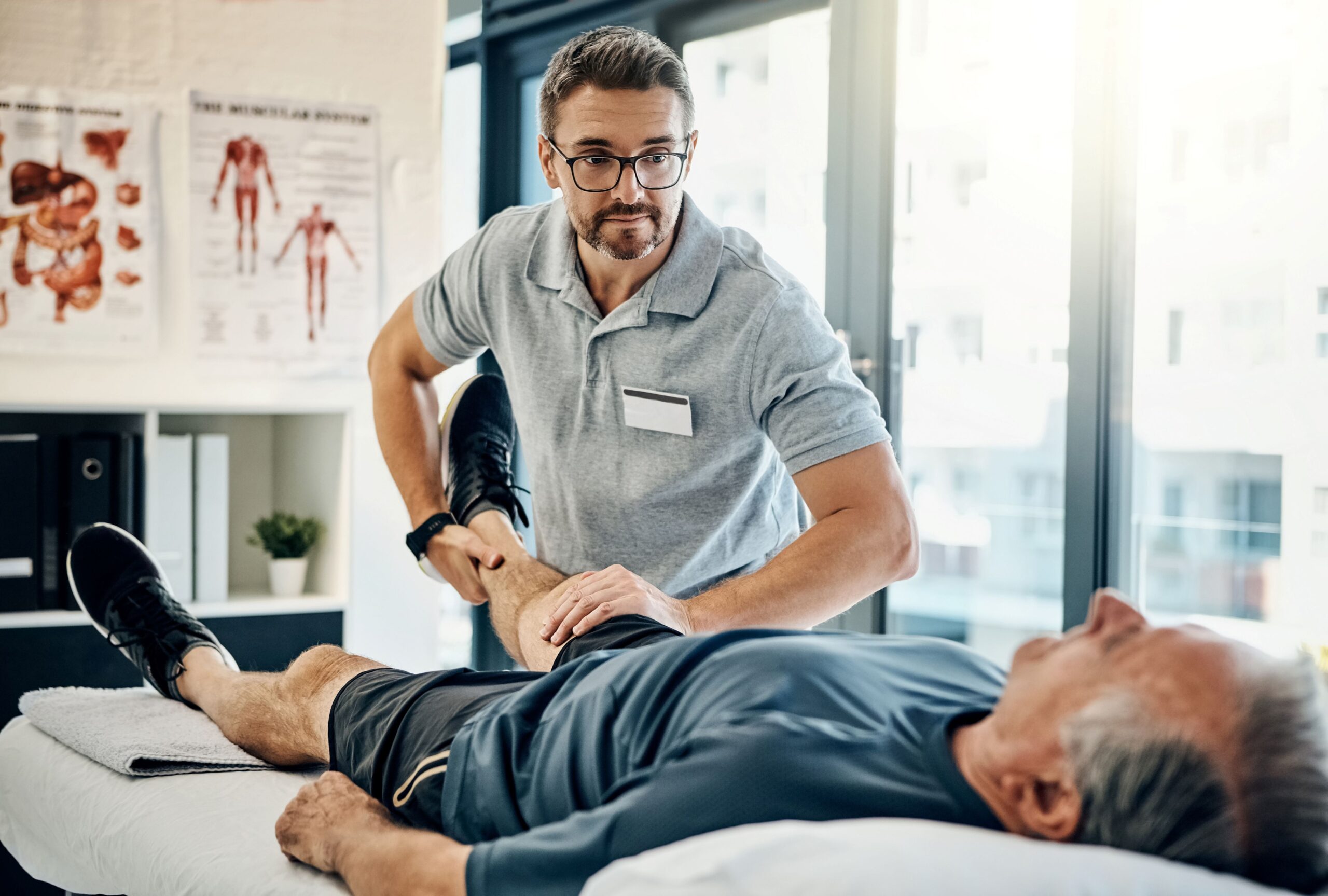 Physiotherapeut behandelt Patienten auf Behandlungsliege in moderner Praxis